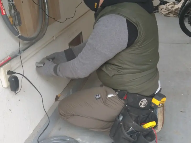 Electrician performing outlet wiring in a Perry garage